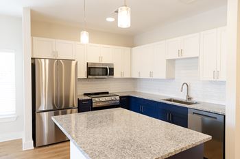 A kitchen with a granite countertop and stainless steel appliances 5